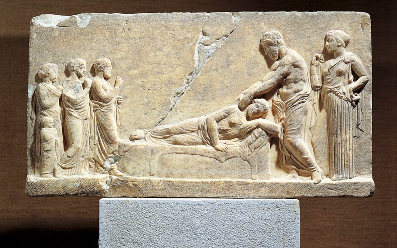 Asklepios untersucht eine Patientin. Links stehen die Angehörigen, hinter dem Arzt die Heilgöttin Hygieia. Relief aus dem 4.Jh.v.Chr.